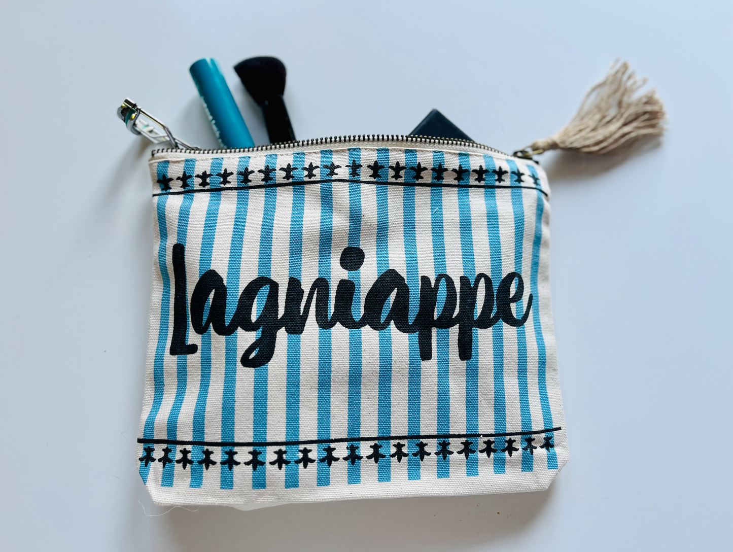 Lagniappe pouch with blue stripes fleur de lis design and brown tassel